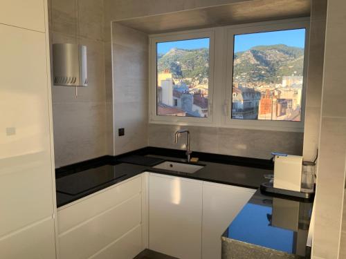 uma cozinha com um lavatório e duas janelas em Port de Toulon Merveilleux ! em Toulon