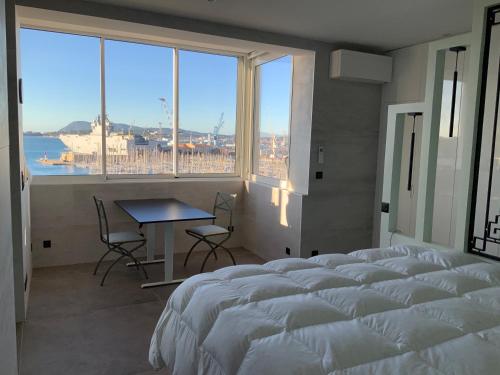 um quarto com uma cama, uma mesa e uma grande janela em Port de Toulon Merveilleux ! em Toulon