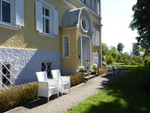 a group of white chairs sitting outside of a house at Alte Villa in Pähl