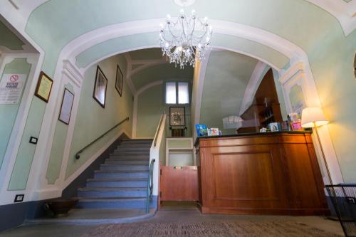 a hallway with a staircase with a chandelier at Hotel Portici in Vicoforte