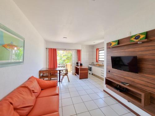 a living room with a couch and a flat screen tv at Apart Hotel Beira do Mar in Florianópolis