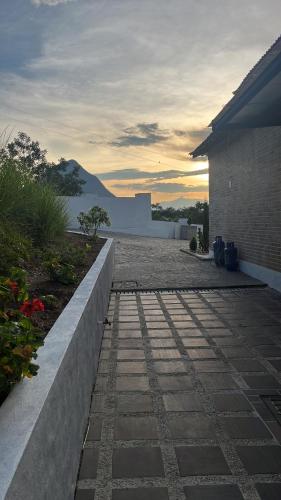 a stone walkway in front of a house with the sunset at Villa Venecia Colonial in Venecia