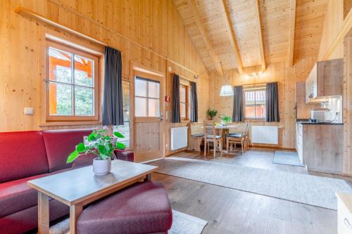 a living room with a red couch and a table at Feriendorf Oberreit in Maishofen