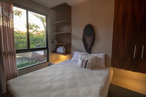 a bedroom with a bed with a large window at BAU Tulum in Tulum