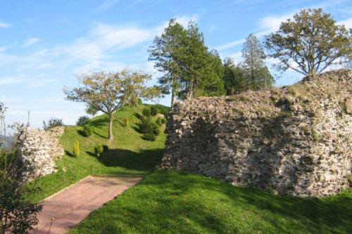 an old stone wall with a path in the grass at Chez Pauline, Gavray. House with secure parking, Wi-Fi & garage. in Gavray