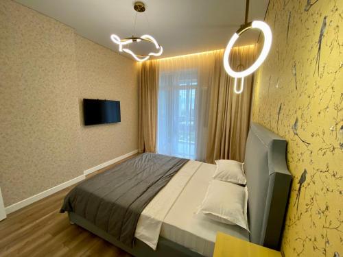sypialnia z łóżkiem i żyrandolem w obiekcie Premium apartment Atlant w mieście Astana