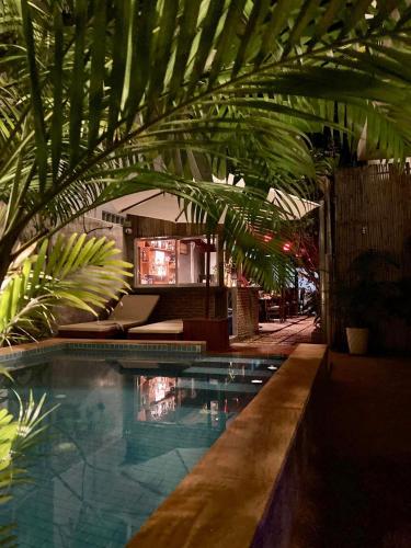 a swimming pool with a palm tree in a building at Lotus Haven Villa in Siem Reap