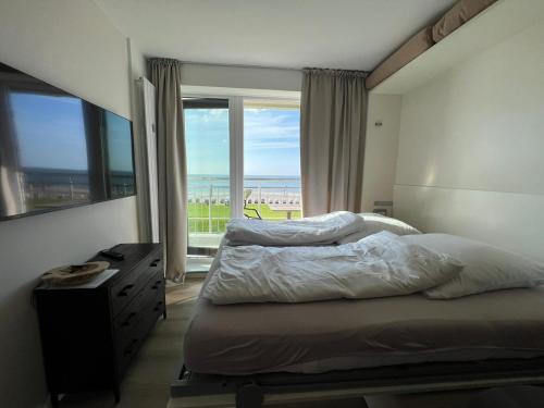 a bedroom with a bed and a large window at Kaiserhof 311 mit Meerblick - Reinke in Norderney