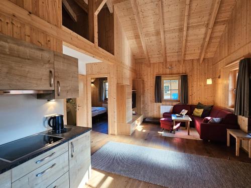 eine Küche und ein Wohnzimmer in einem Blockhaus in der Unterkunft Feriendorf Oberreit in Maishofen