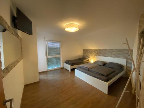 a bedroom with two beds and a television in it at Ferienwohnung Vogelsang in Laufenburg