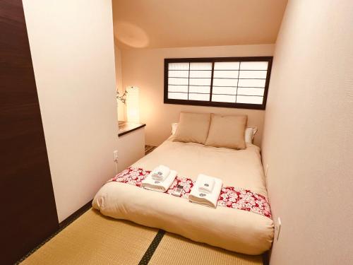Un pequeño dormitorio con una cama con dos teléfonos. en 天王寺駅から徒歩7分 en Osaka
