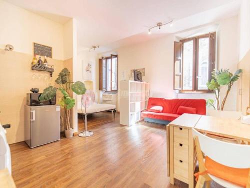 a living room with a red couch and a red chair at appartamento centro storico con cucina, servizio streming, vicino a tutte le attrazioni del posto in Viterbo