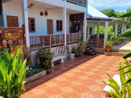 a porch of a house with plants and a bench at Sawasdee Sichang Resort in Ban Tha Thewawong
