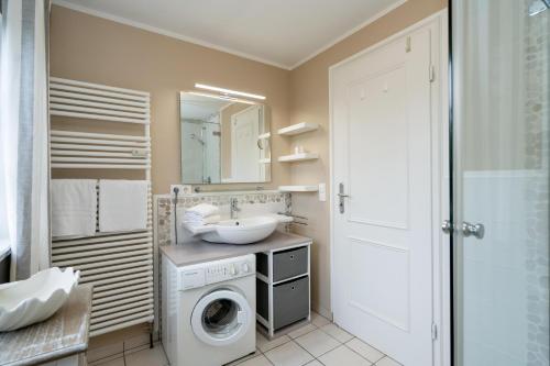 a bathroom with a sink and a washing machine at Haus Shelly in Keitum