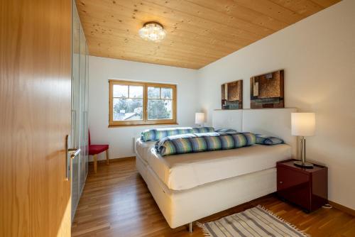- une chambre avec un lit et un plafond en bois dans l'établissement Trü-Sura Nr. 9, à Scuol