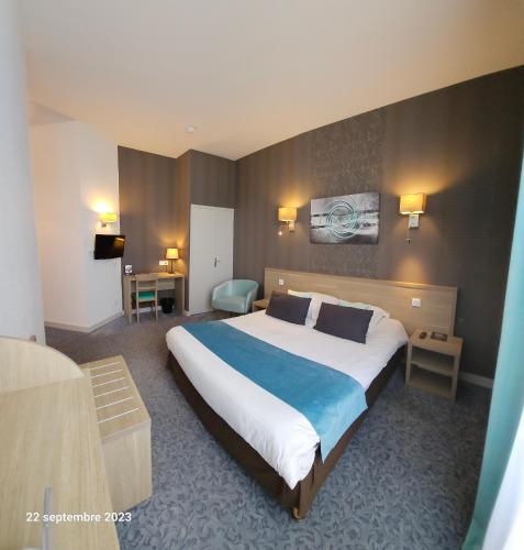 a bedroom with a large bed in a hotel room at Hôtel Le Rohan Charme et Caractère in Pontivy