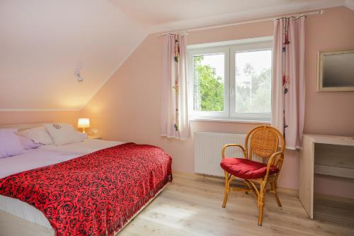 a bedroom with a bed and a chair and a window at Bednarzówka in Nowy Tomyśl