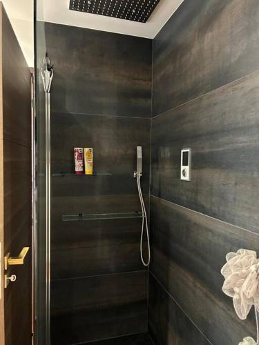 uma casa de banho com um chuveiro e um telefone na parede em Logement proche Stade de France em Saint-Denis