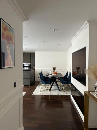 un salon avec une table et des chaises bleues dans l'établissement Logement proche Stade de France, à Saint-Denis