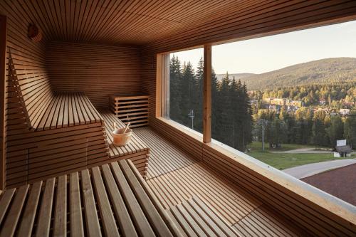 a wooden balcony with a view of the mountains at Ski & Spa hotel BELLEVUE in Harrachov