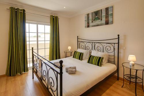 a bedroom with a black bed with green curtains at Private Deluxe 3BD Villa Pool Wi-Fi AC BBQ in Albufeira
