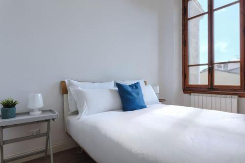 una camera da letto con un letto bianco e una finestra di Porta a Prato 46 a Firenze