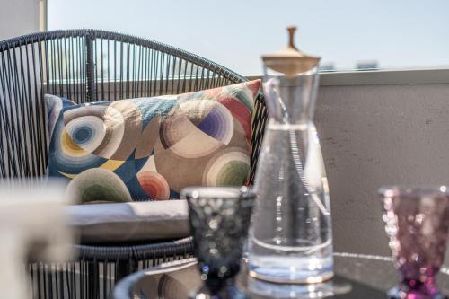 a chair with a pillow and a vase on a table at hirschen dornbirn - das boutiquestyle hotel - skyrelax & wellness im rooftop in Dornbirn