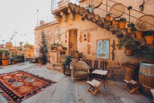 a building with a room with chairs and a rug at La maison de Şişik in Uchisar