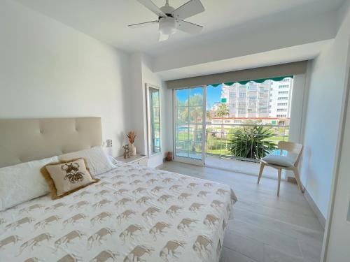 Un dormitorio blanco con una cama y una ventana grande. en Summer`s Dream, en Benalmádena