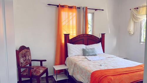 a bedroom with a bed and a chair and a window at City suite Apartment 1 Cabrera in Cabrera