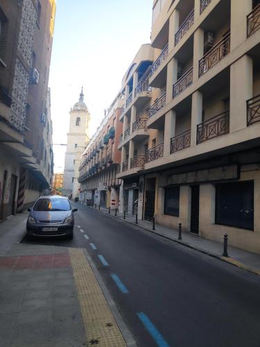 a car driving down a street next to a building at La Florida in Ciudad Real