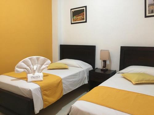 een hotelkamer met twee bedden en een bordje erop bij Hotel Arcadia Colonial in Popayan