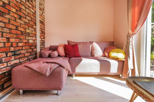 a living room with a couch and a brick wall at Bednarzówka in Nowy Tomyśl