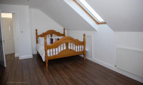 1 dormitorio con cama de madera en una habitación blanca en Humberts Lodge, 