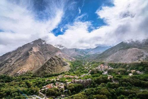 Blick auf eine Stadt in einem Tal mit Bergen in der Unterkunft Imlil in Marrakesch