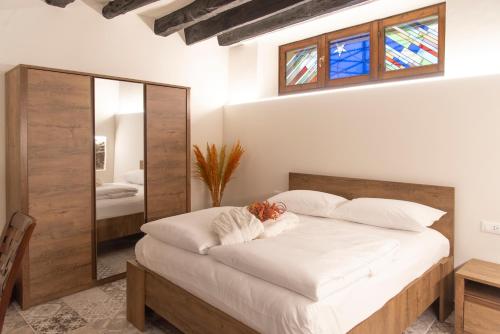 een slaapkamer met een groot bed en een spiegel bij LA CURT guest house in Artogne