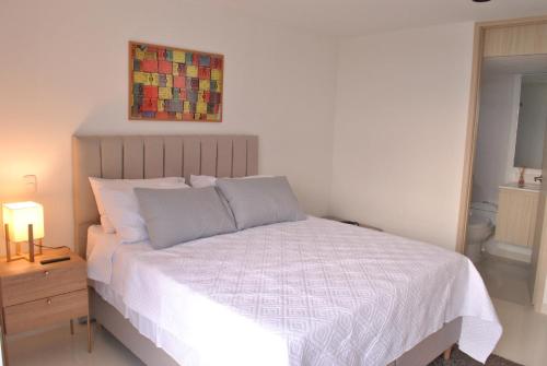 ein Schlafzimmer mit einem Bett mit einer weißen Bettdecke in der Unterkunft Lujoso apartamento frente al mar in Tubará