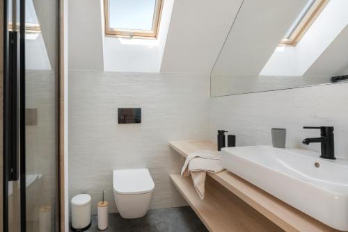 a white bathroom with a sink and a toilet at Siema Siemiany in Siemiany