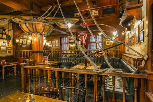 a restaurant with a bar with a table and chairs at Nelson Hotel in Hajdúszoboszló