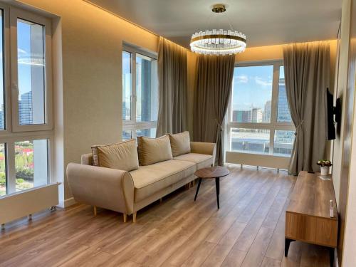 salon z kanapą i dużymi oknami w obiekcie Premium apartment Atlant w mieście Astana