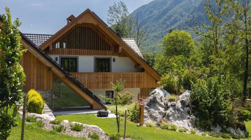 a house with a mountain in the background at PRIVILLAGE Stare - Villa & Chalet in Bohinj
