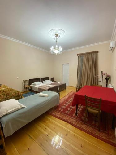 Zimmer mit 2 Betten und einem roten Tisch in der Unterkunft Season in Kutaissi