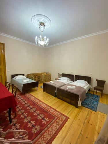 Zimmer mit 2 Betten und einem Kronleuchter in der Unterkunft Season in Kutaissi