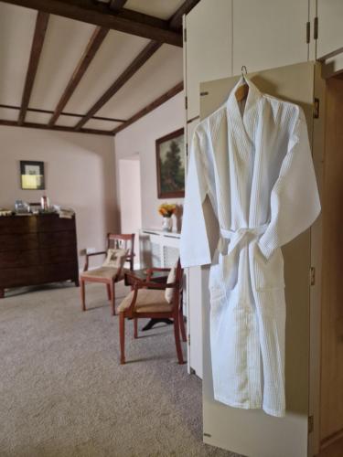 a white robe hanging on a door in a room at Primroses, Wood Farm in Shipdham