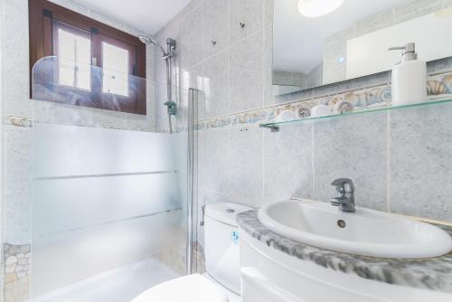 a white bathroom with a sink and a toilet at CHIC, COSY & QUIET Apartment near the beach in Mogán