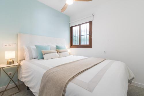 a bedroom with a large white bed with a window at CHIC, COSY & QUIET Apartment near the beach in Mogán