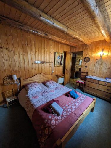 Cette chambre en bois comprend un grand lit. dans l'établissement Belle Vue Des Praz, à Chamonix-Mont-Blanc