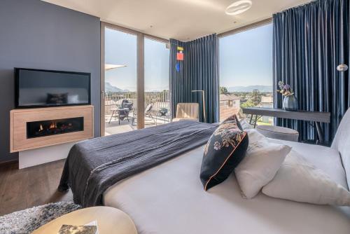 een slaapkamer met een bed, een open haard en een televisie bij hirschen dornbirn - das boutiquestyle hotel in Dornbirn