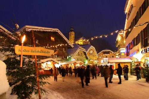 a group of people walking through a christmas market at night at Appartements Wirnsperger in Grossarl