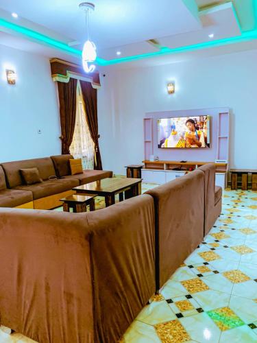 a living room with couches and a flat screen tv at Select Winsome 1 Room, 1 King-sized Bed in Abuja